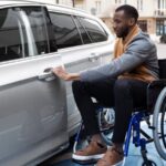 Homem em cadeira de rodas abrindo porta de carro