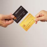 Duas mãos segurando cartão de crédito
